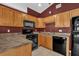 Cozy kitchen with stainless steel appliances, tile flooring, black microwave, and wooden cabinets at 205 Twisting Trl, Orlando, FL 32825