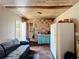 Living room with blue loveseat, ceiling, fridge, cabinets, faux wood floors, and a doorway to the bathroom at 2342 Linda St, Lake Wales, FL 33898