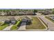 Aerial view of a home showcasing a manicured lawn and a neatly paved driveway at 2451 Spring Breeze Dr, Leesburg, FL 34748