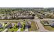 An elevated shot of a home and its surrounding neighborhood, featuring lush landscapes and clear blue skies at 2451 Spring Breeze Dr, Leesburg, FL 34748