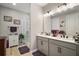 Bathroom featuring double vanity, modern finishes, decorative mirror and framed art at 2451 Spring Breeze Dr, Leesburg, FL 34748