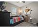 Neutrally painted bedroom with a colorful daybed, large window, and decorative art at 2451 Spring Breeze Dr, Leesburg, FL 34748