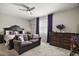 Primary bedroom with plush carpeting, a ceiling fan, and coordinated furniture at 2451 Spring Breeze Dr, Leesburg, FL 34748