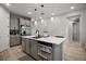 Kitchen island with stainless steel appliances, gray cabinets, and a white quartz countertop at 2451 Spring Breeze Dr, Leesburg, FL 34748