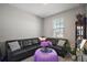 Sitting room with modern black leather furniture, purple floral arrangement, and window view at 2451 Spring Breeze Dr, Leesburg, FL 34748