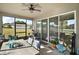 Bright screened-in patio with seating area, ceiling fan, and view of the lush outdoors at 2451 Spring Breeze Dr, Leesburg, FL 34748