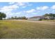 Neighborhood street showcasing residences with green lawns and sidewalks under a partly cloudy sky at 2451 Spring Breeze Dr, Leesburg, FL 34748