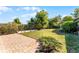 Spacious backyard with a brick patio and garden beds, offering a serene outdoor setting at 2545 Dellwood Dr, Orlando, FL 32806