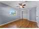 Light blue bedroom with hardwood floors, closet, and a window at 2545 Dellwood Dr, Orlando, FL 32806