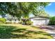 Charming single-story home featuring a manicured lawn, brick accents, attached two-car garage, and mature trees at 2545 Dellwood Dr, Orlando, FL 32806