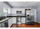 Modern kitchen features stainless steel appliances, granite countertops, and white cabinets, offering storage and a sleek look at 2545 Dellwood Dr, Orlando, FL 32806