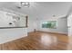 Open-concept living space with hardwood floors, bright windows, and seamless flow into dining and kitchen areas at 2545 Dellwood Dr, Orlando, FL 32806