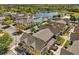 Community aerial view featuring a swimming pool, pond, clubhouse and townhomes nestled within lush greenery at 2624 Lodi Cir # 101, Kissimmee, FL 34746
