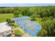 Aerial view shows basketball, tennis, and volleyball courts with surrounding trees at 2624 Lodi Cir # 101, Kissimmee, FL 34746