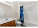 Bright bathroom with wood cabinets, white sink and toilet, and shower/tub with curtain at 2624 Lodi Cir # 101, Kissimmee, FL 34746
