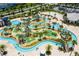 Aerial view of a resort-style lazy river with mini golf, lush landscaping and shady palm trees at 2805 Bookmark Dr, Kissimmee, FL 34746