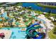 Aerial view of a resort-style lazy river with water slides, mini golf, landscaping and shady palm trees at 2805 Bookmark Dr, Kissimmee, FL 34746