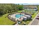 Aerial view of community pool with palm trees, lounge seating, picnic tables, a clubhouse and other recreation at 2805 Bookmark Dr, Kissimmee, FL 34746