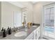 Bathroom featuring double sinks, a large mirror, and a view to the pool area at 2805 Bookmark Dr, Kissimmee, FL 34746