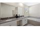 Bathroom with double sinks, vanity area, large mirror and a soaking tub at 2805 Bookmark Dr, Kissimmee, FL 34746