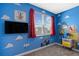 bedroom with blue walls, colorful cartoon characters, and a large window at 2805 Bookmark Dr, Kissimmee, FL 34746
