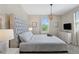 Bedroom showcasing a tufted headboard, dresser and a bright, light-filled window at 2805 Bookmark Dr, Kissimmee, FL 34746