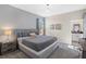 Gray-themed bedroom featuring a large bed, patterned wallpaper, and a view into the bathroom at 2805 Bookmark Dr, Kissimmee, FL 34746
