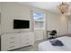 Bright bedroom featuring a dresser with TV, desk, and stylish lighting at 2805 Bookmark Dr, Kissimmee, FL 34746