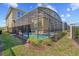 A screened enclosure includes a pool and hot tub area, extending from a tan house with neat landscaping at 2805 Bookmark Dr, Kissimmee, FL 34746