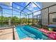 Beautiful screened pool area with view of trees and blue sky, with a nearby hot tub and pink pool float at 2805 Bookmark Dr, Kissimmee, FL 34746
