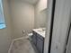 Neutral powder room with grey vanity, marble floors, and sink at 2978 Aqua Virgo Loop # 13, Orlando, FL 32837