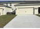 A spacious two car garage with a paved driveway and manicured lawn at 2978 Aqua Virgo Loop # 13, Orlando, FL 32837
