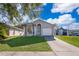 Well-maintained single-Gathering home boasts a pristine lawn, tree coverage, and attached two-car garage at 3063 Jon Jon Ct, Orlando, FL 32822