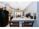 Efficient kitchen with light wood cabinets, white countertops, black appliances, and an adjacent breakfast nook at 3063 Jon Jon Ct, Orlando, FL 32822
