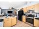 Open-concept kitchen with light wood cabinets, stainless steel appliances, and connecting living room view at 3063 Jon Jon Ct, Orlando, FL 32822
