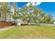 Spacious backyard featuring lush green grass, mature trees, park benches, and a private dock on the serene lake at 3107 Troy Dr, Orlando, FL 32806