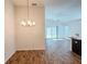 Open concept dining and living area with modern lighting and wood flooring at 3437 Possehl Pl, The Villages, FL 32163