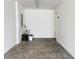 Spacious garage with a concrete floor, white walls, and standard garage door; ample room for vehicles and storage at 3437 Possehl Pl, The Villages, FL 32163