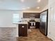 A modern kitchen with stainless steel appliances and dark cabinetry at 3437 Possehl Pl, The Villages, FL 32163
