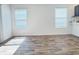 Bright living room with vinyl wood flooring and ample natural light from two windows at 3437 Possehl Pl, The Villages, FL 32163