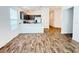 A well-lit living room adjacent to a kitchen with vinyl wood flooring at 3437 Possehl Pl, The Villages, FL 32163