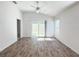 Living room with a sliding door to the backyard and wood-style flooring at 3437 Possehl Pl, The Villages, FL 32163