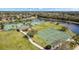 Aerial view of the athletic area featuring basketball and tennis courts along the pond at 3616 Deer Oak Cir, Oviedo, FL 32766