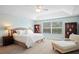 Spacious main bedroom featuring tray ceilings, soft carpet, and a view of the greenery outside at 3616 Deer Oak Cir, Oviedo, FL 32766