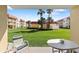 Balcony view of a lush green lawn surrounded by multiple buildings and palm trees at 3801 S Atlantic Ave # 114, New Smyrna Beach, FL 32169