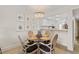 Charming dining area with seating for four, framed nautical prints, and views into the adjacent kitchen at 3801 S Atlantic Ave # 114, New Smyrna Beach, FL 32169