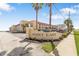 Inviting view of Point East exterior featuring a manicured lawn and swaying palm trees at 3801 S Atlantic Ave # 114, New Smyrna Beach, FL 32169