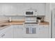 Efficient kitchen with white cabinetry, microwave, and electric range at 3801 S Atlantic Ave # 114, New Smyrna Beach, FL 32169