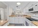 Bright kitchen with stainless steel sink, white appliances, and adjacent dining area at 3801 S Atlantic Ave # 114, New Smyrna Beach, FL 32169