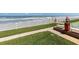 Beautiful ocean view by a shuffleboard court with a white picket fence and lush green grass at 3801 S Atlantic Ave # 114, New Smyrna Beach, FL 32169